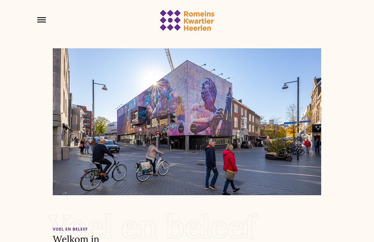 In het Heerlense Romeins Kwartier lopen en fietsen mensen langs gebouwen met kleurrijke muurschilderingen.